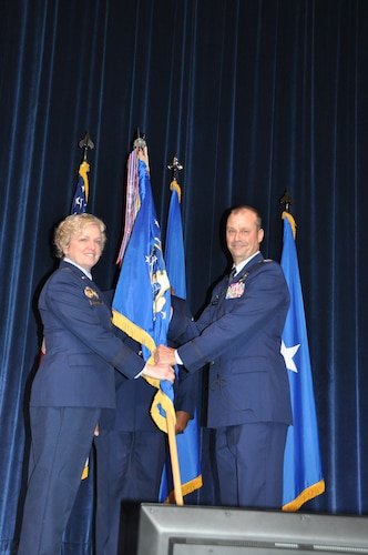 a person hands another person a flag