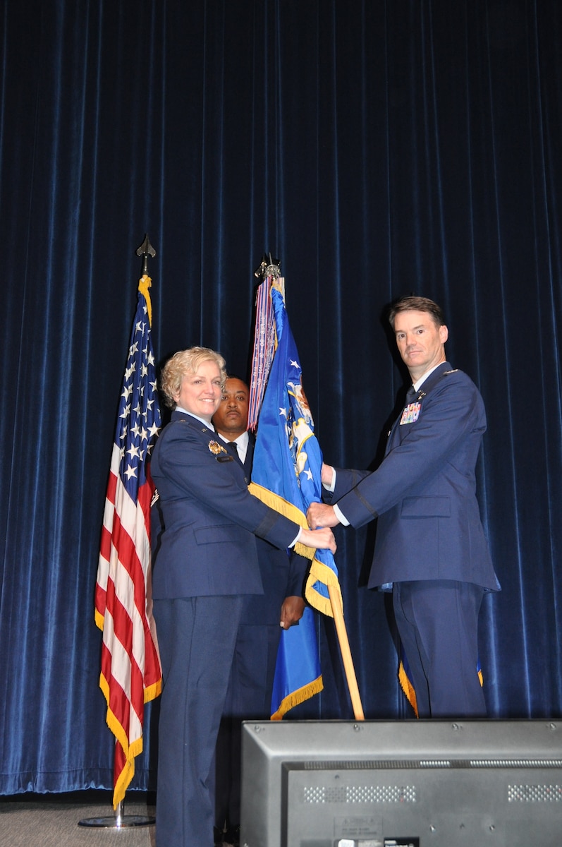 A person hands another person a flag