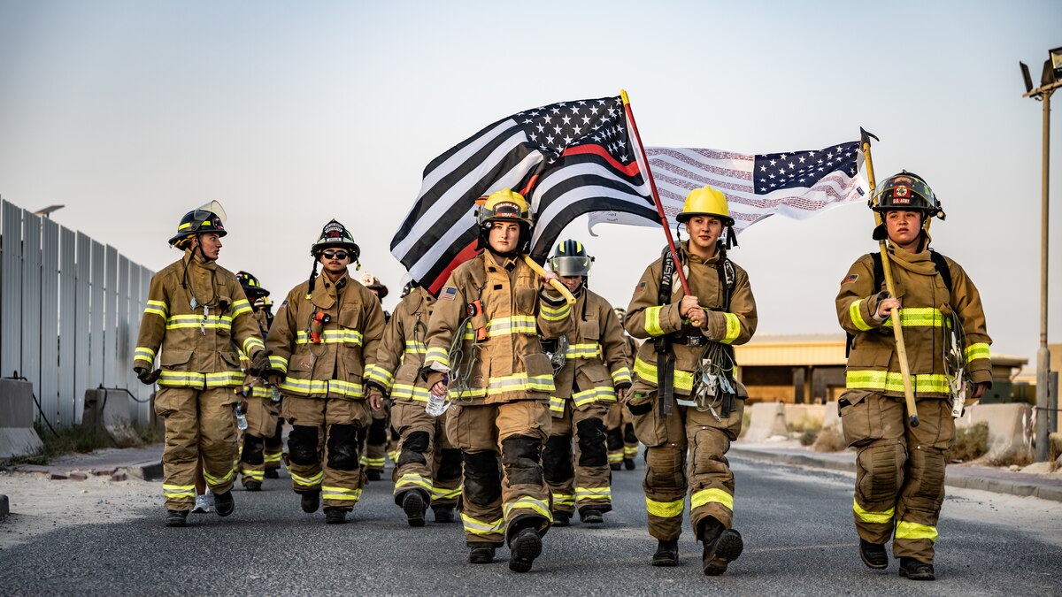 U.S. Air Force fire protection Airmen from the 386th Expeditionary Civil Engineer Squadron stride forward together during the 9/11 memorial ruck march at Ali Al Salem Air Base, Kuwait, Sept. 11, 2023. Service members from the U.S., Canada, Italy, and Denmark gathered together today for a moment of silence followed by a ruck march in remembrance of the innocent lives lost during the attacks on this fateful day 22 years ago. Sharing the past with our coalition partners secures a brighter future for us all. (U.S. Air Force photo by Staff Sgt. Kevin Long)