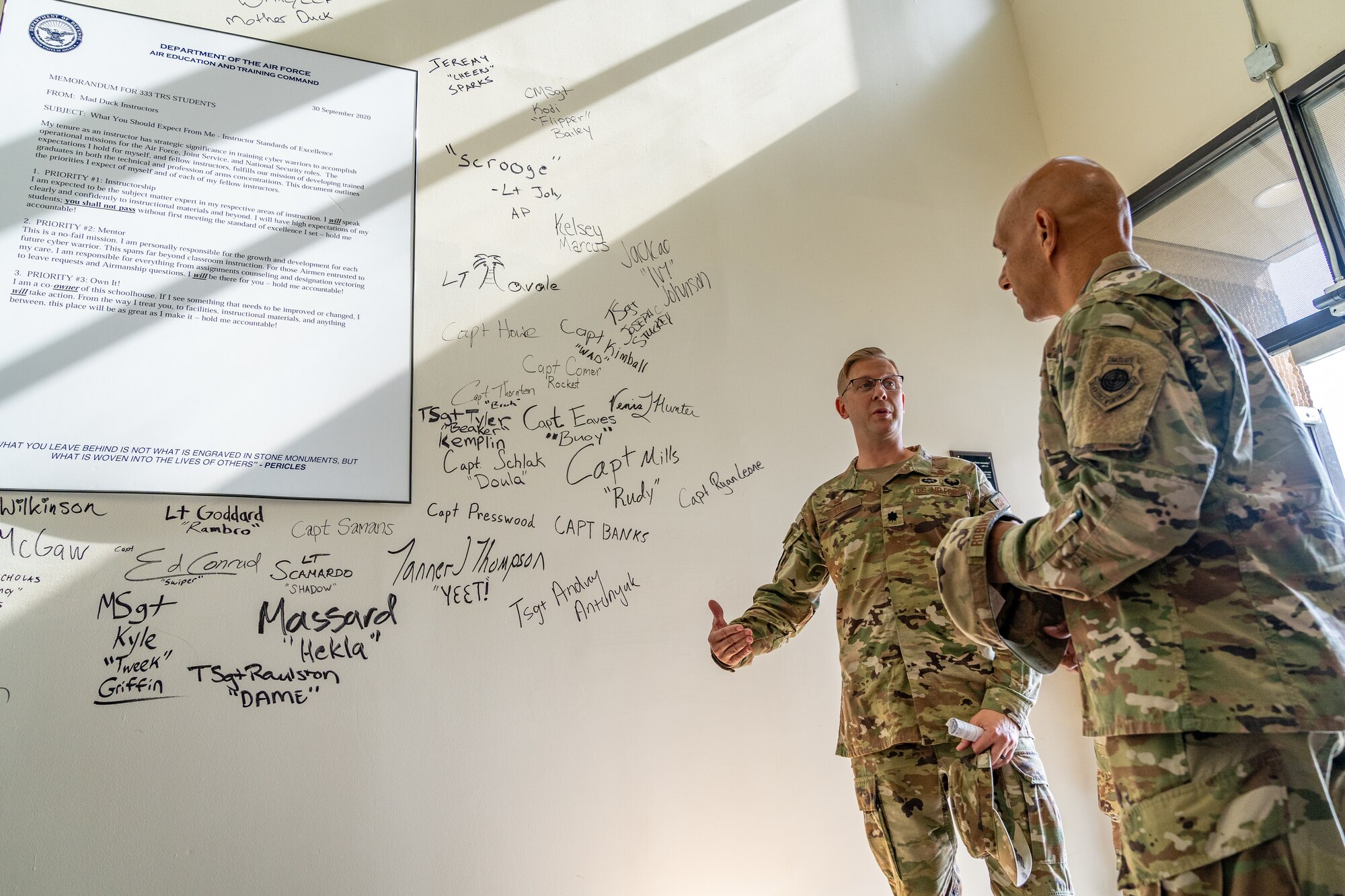 U.S. Air Force Lt. Col. Nicholas Kuc, 333rd Training Squadron commander, shows Lt. Gen. Brian Robinson, commander of Air Education and Training Command, the wall master instructors sign at Keesler Air Force Base