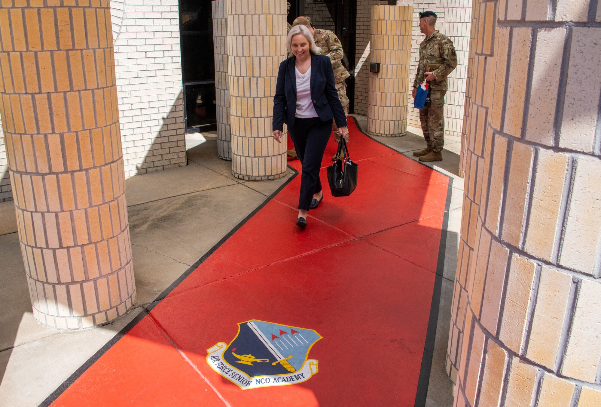 Crystal Moore, director of Force Development, Headquarters Air Force, walks the “red carpet’ outside the Air Force Senior Noncommissioned Officer Academy during an enlisted professional military education immersion at Maxwell Air Force Base, Gunter Annex, Ala., Sept. 7, 2023. (U.S. Air Force photo/Brian Ferguson)