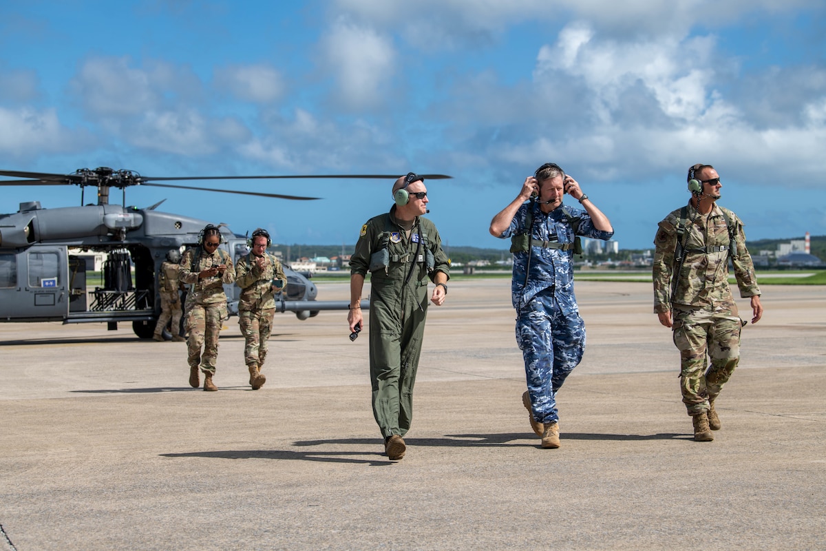 Wing commanders and distinguished visitor walk away from helicopter