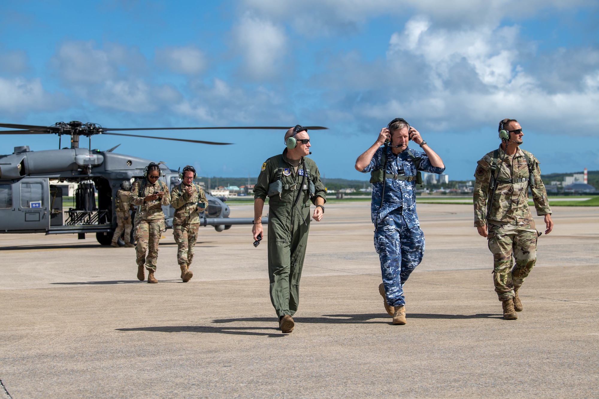 Wing commanders and distinguished visitor walk away from helicopter