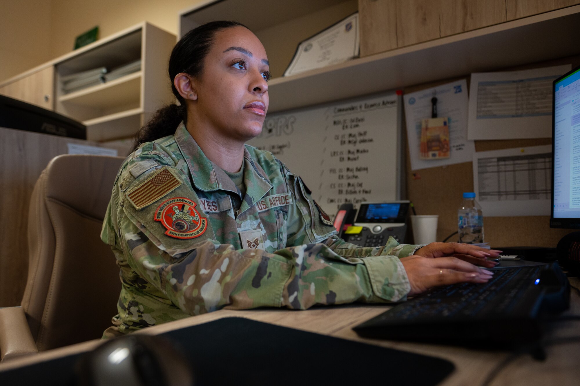 A female Airman works on a computer.