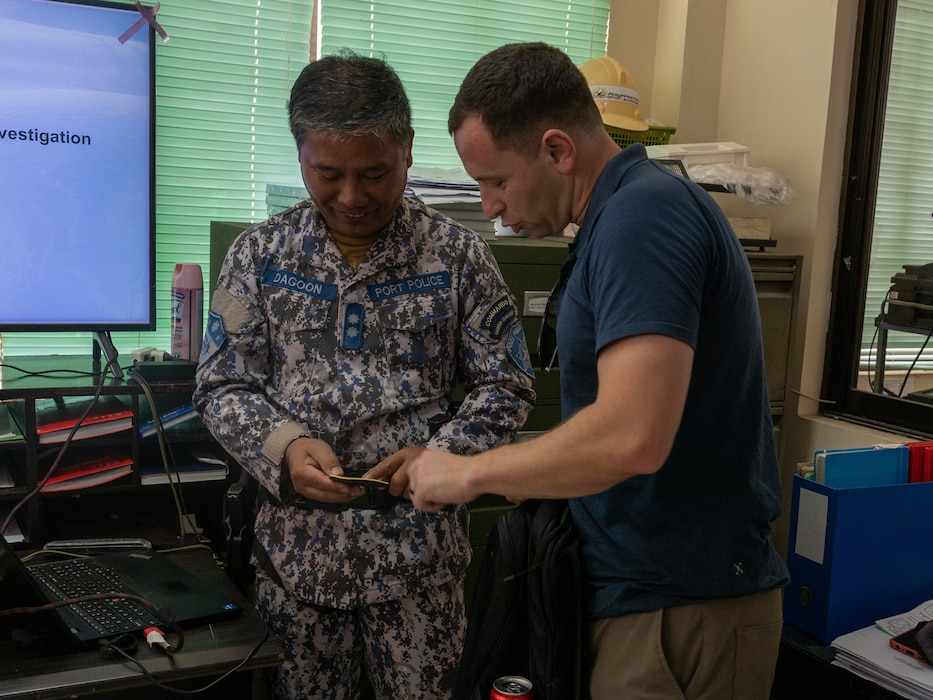 U.S. Marine Corps Maj. Zachary Goodman, a civil affairs officer with 3rd Civil Affairs Group, Force Headquarter Group, Marine Force Reserves, gifts Philippine Coast Guard Cmrd. Salvador Dagoon Jr., port authority head of security, a unit patch during Balikatan 23 in Antique, Philippines, April 14, 2023.