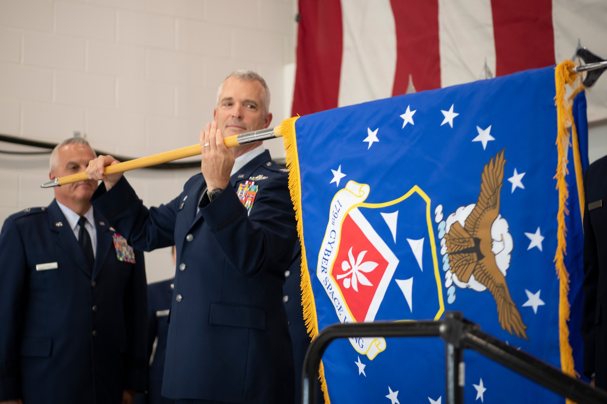 Col. Darren Hamilton, commander of The 179th Airlift Wing, an Ohio Air National Guard unit, reveals the new flag as the unit is redesignated as the 179th Cyberspace Wing