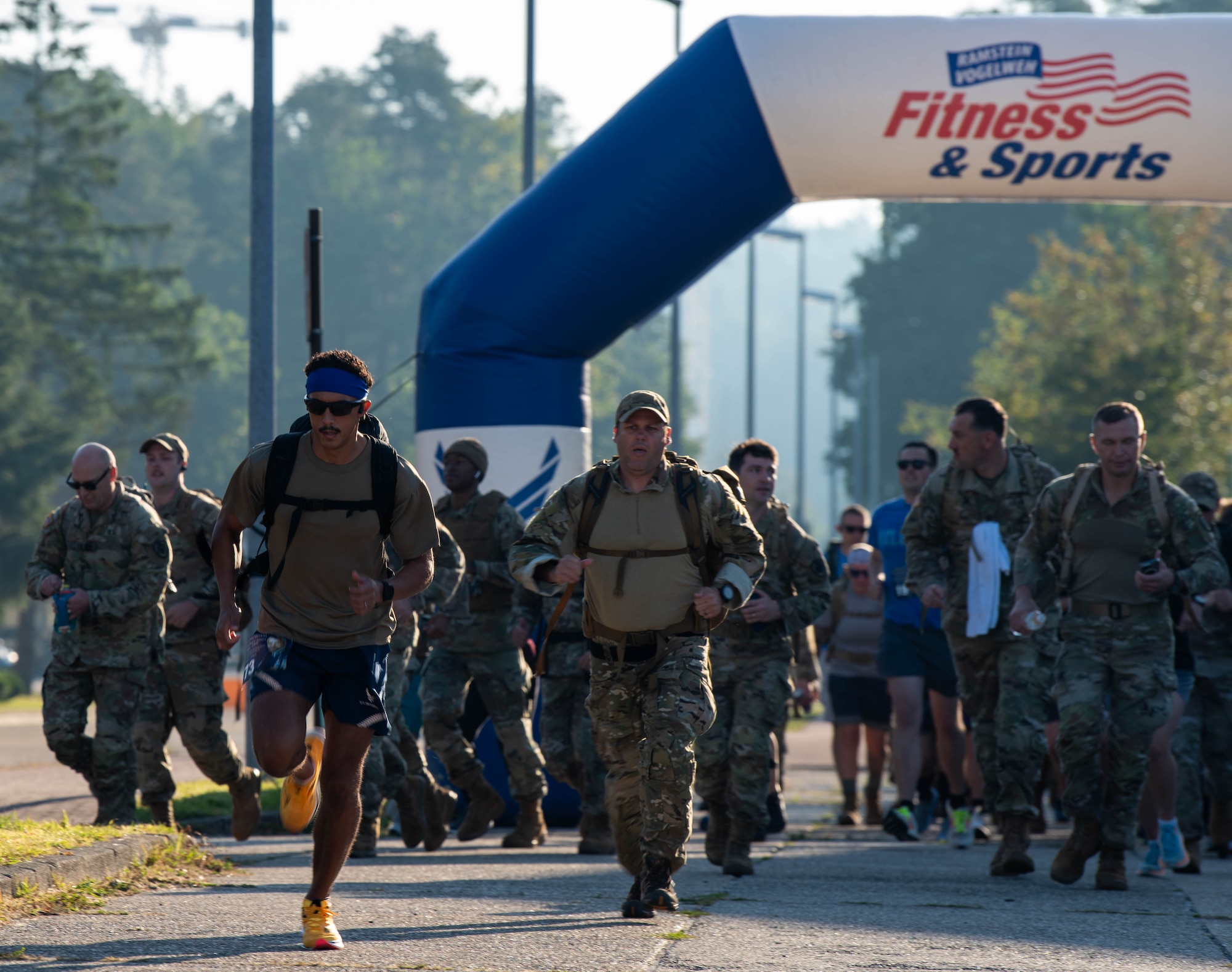 Service members run in a ruck.