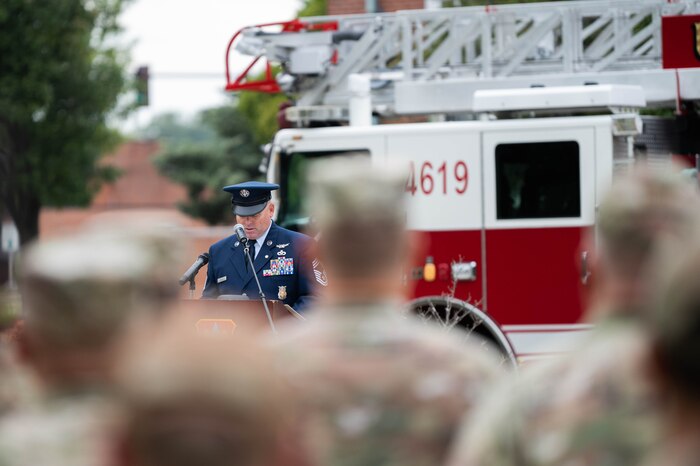 An Air Force member gives a speech at a podium in front of crowd.