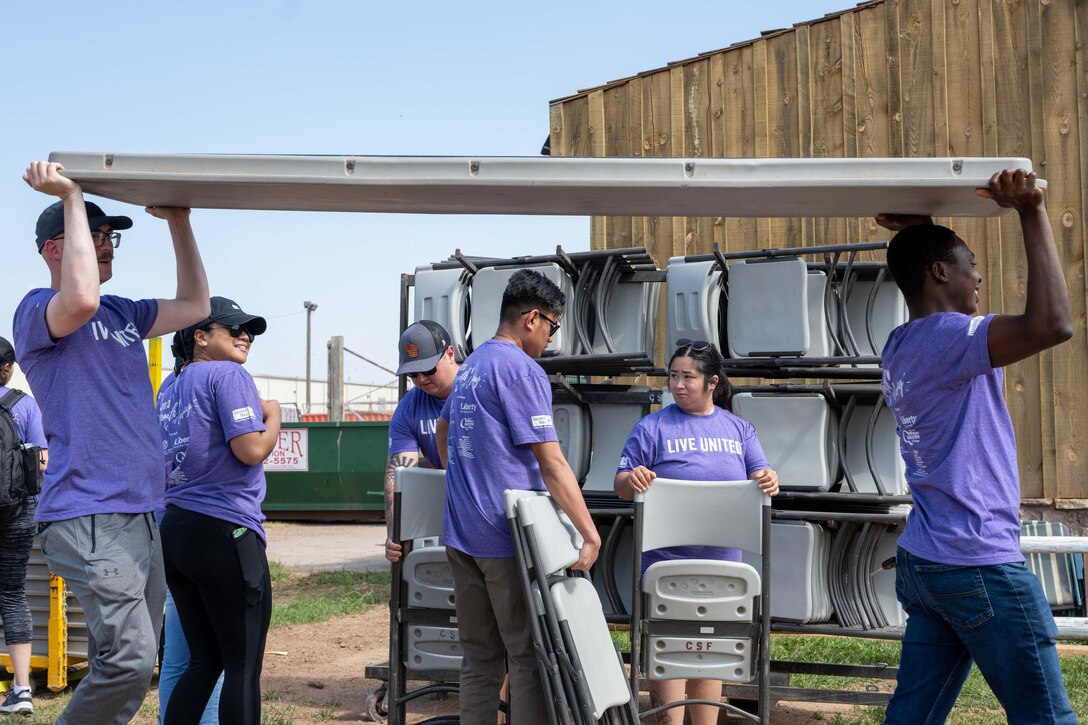 Volunteers from Ellsworth Air Force Base arrange tables and chairs at the Central States Fairgrounds in Rapid City, South Dakota, Sept. 7, 2023. These Airmen prepared a celebratory barbecue to commemorate the completion of the Day of Caring events around the city. (U.S. Air Force photo by Spc3 Adam Olson)