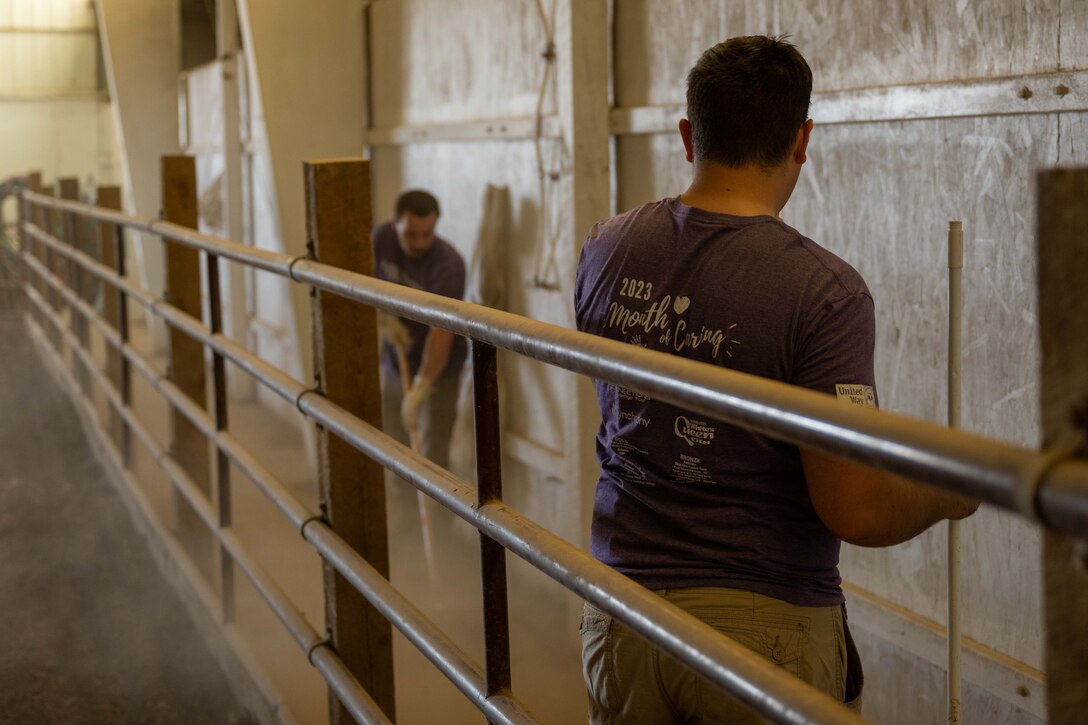 Volunteers from Ellsworth Air Force Base clean an indoor horse arena at The Barn in Rapid City, South Dakota, Sept. 7, 2023. Ellsworth Airmen volunteered help their local community with jobs such as cleaning, yardwork, demolition, and animal care. (U.S. Air Force photo by Spc3 Adam Olson)