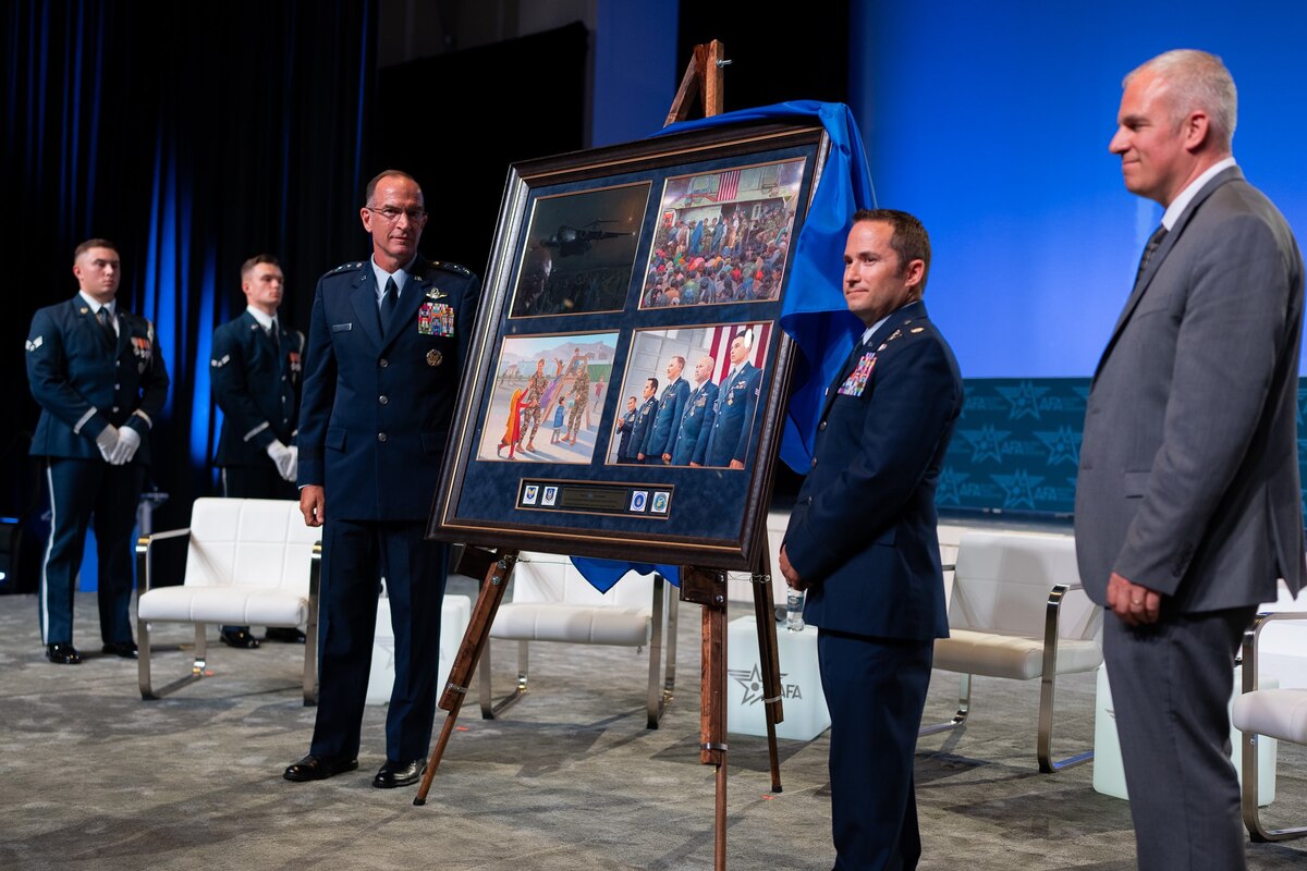three people showcase the newly unveiled 75th anniversary painting