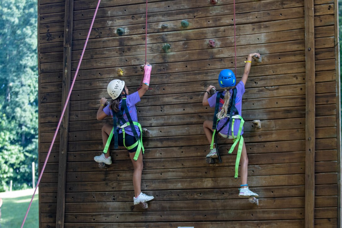 Two campers race to the top of a wall climbing tower at the 2023 Kentucky National Guard Youth Camp.