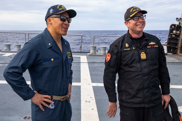 Cmdr. Isaia Infante, left, commanding officer of Arleigh Burke-class guided-missile destroyer USS Ralph Johnson (DDG 114) speaks with Cmdr. Sam Patchell, right, commanding officer of His Majesty’s Canadian Ship (HMCS) Ottawa (FFH 341) during a visit to Ralph Johnson Sep. 6 in the South China Sea. Ralph Johnson is assigned to Commander, Task Force 71/Destroyer Squadron (DESRON) 15, the Navy’s largest forward-deployed DESRON and the U.S. 7th Fleet’s principal surface force.