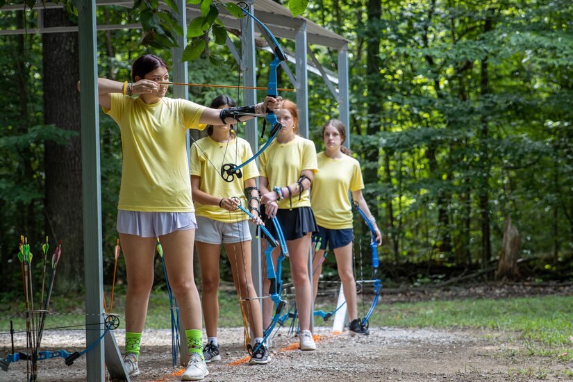 A camper draws back on a bow while learning archery at the Kentucky National Guard Youth Camp.