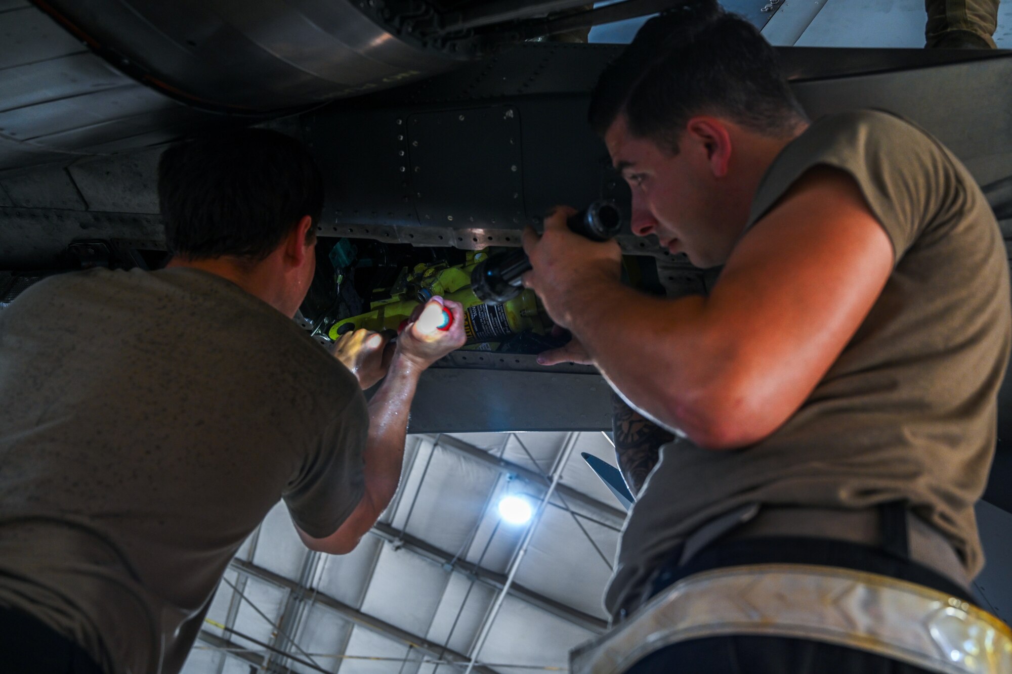 Staff Sgt. Ethan Tentler, left, 414th Maintenance Squadron crew chief, and Master Sgt. Justin Hosier, 414th MXS crew chief, installs a stab actuator on an F-15E Strike Eagle at Seymour Johnson Air Force Base, North Carolina, Aug. 22, 2023.
