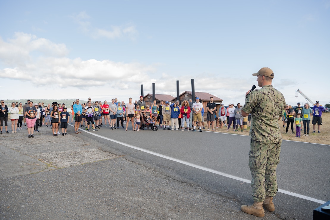Lt. Cmdr. Sam Clement, executive officer, Naval Magazine Indian Island, speaks to race participants at Naval Magazine Indian Island during the Deer Run in Port Hadlock, Washington, August 13, 2022. About 150 runners and walkers participated in this year’s 5k and 1-mile Deer Run, which NMII typically hosts every year in the summer. (U.S. Navy photo by Mass Communication Specialist Seaman Apprentice Sophia H. Brooks)