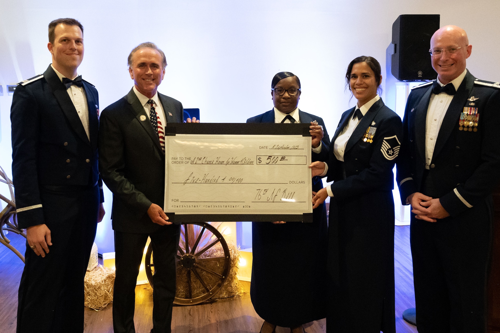 Team Dover presents a $500 check to the non profit organization A 2nd Chance Haven For Women and Children, on behalf of Sen. Eric Buckson, second from the left,  during the 76th Air Force Ball in Dover, Delaware, Sept. 8, 2023. The Dover AFB Air Force Ball celebrated the 76th anniversary of the U.S. Air Force. (U.S. Air Force photo by Airman 1st Class Dieondiere Jefferies)