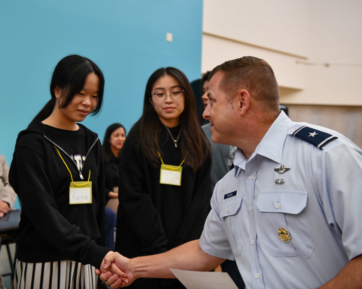 U.S. Air Force Brig. Gen. Jesse Friedel, Fifth Air Force deputy commander, congratulates a team of students for winning the “Best Character” award at the Student Educational Exchange and Dialogue (SEED) project at Yokota Air Base, Japan, Sept. 10, 2023. SEED is a project meant to bring American and Japanese students together to participate in educational and cultural exchange activities at Department of Defense Education Activity Pacific  schools located on U.S. military installations in Japan. (U.S. Air Force photo by Staff Sgt. Spencer Tobler)