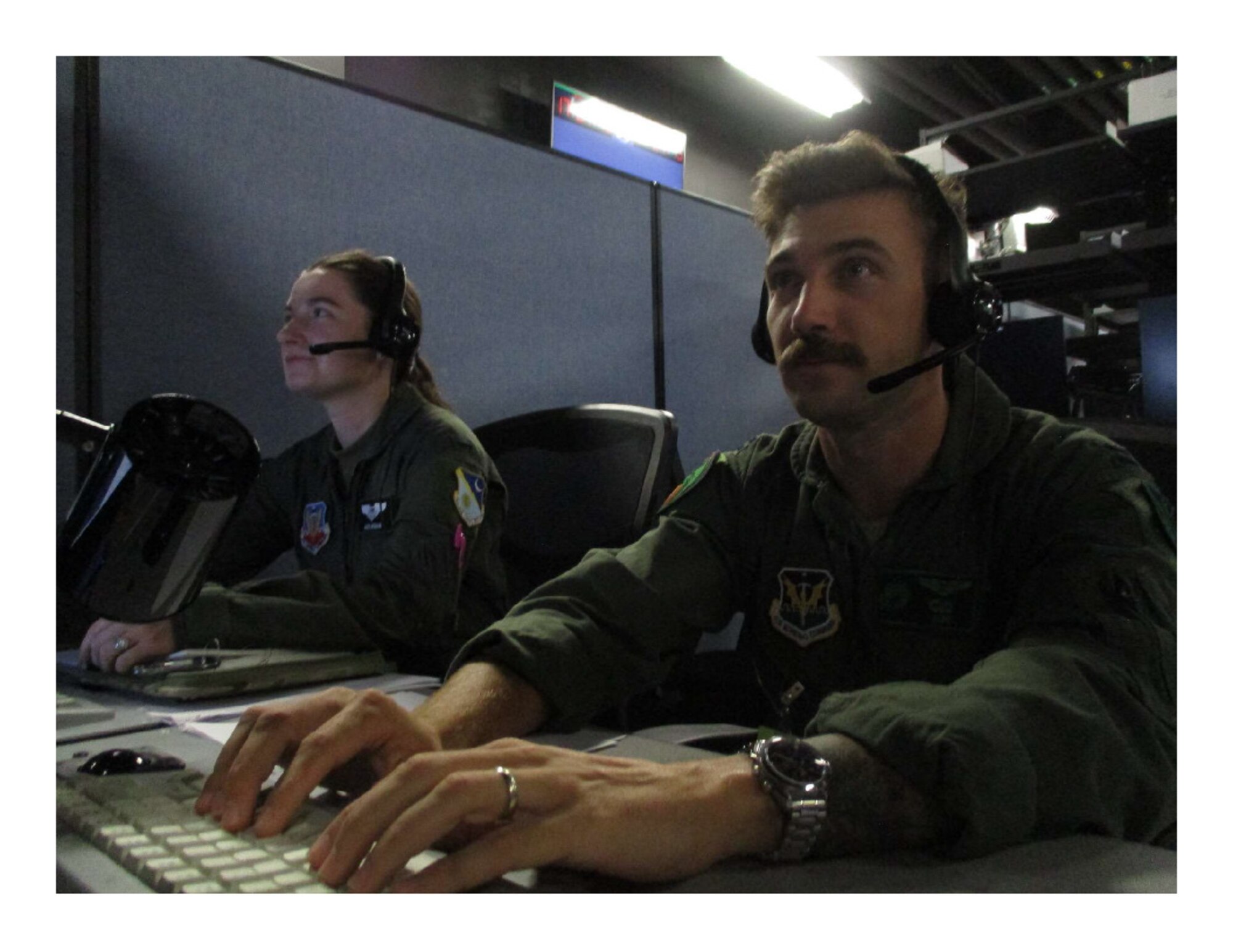 photo of uniformed U.S. Military man and woman look at computer screens
