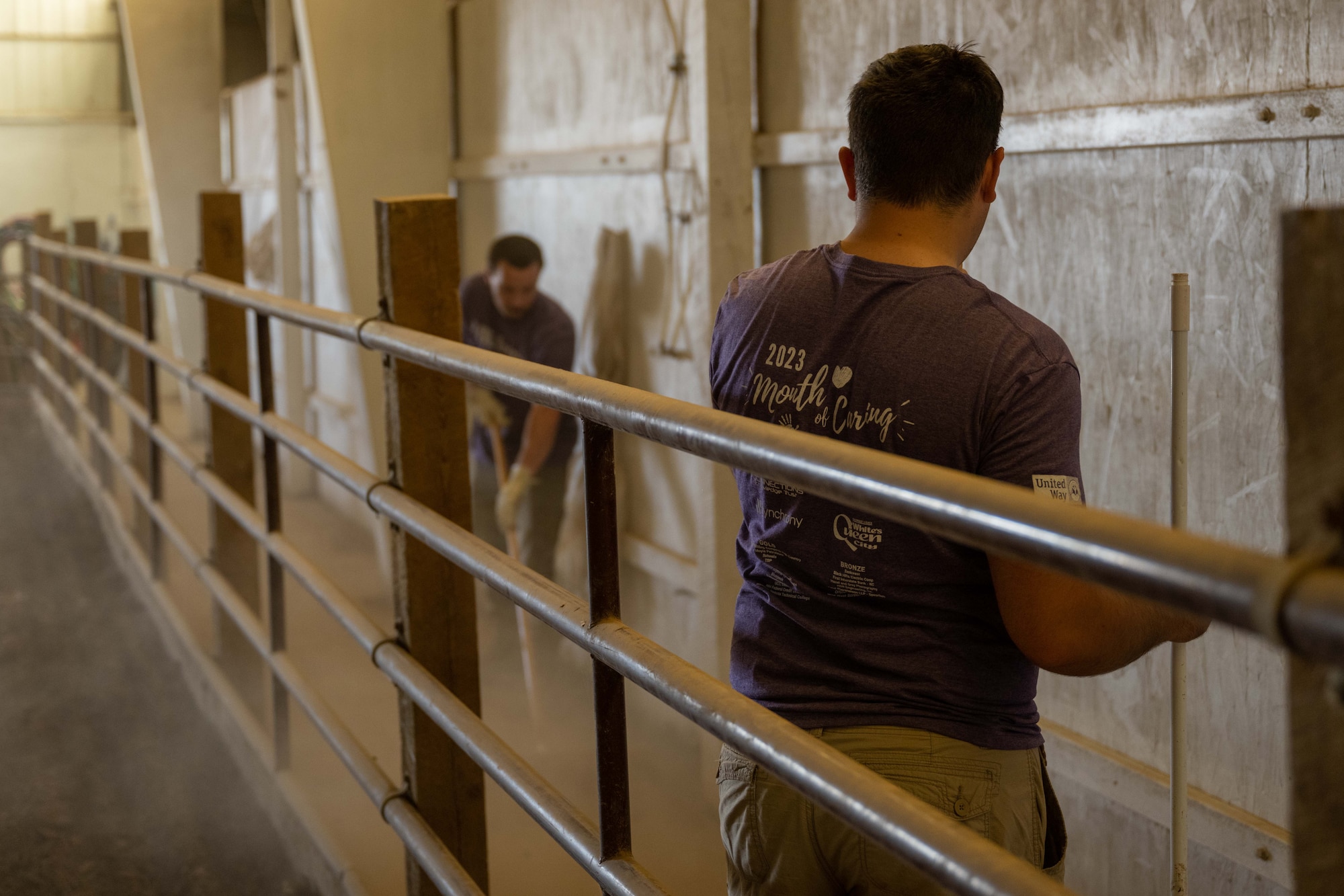 Volunteers from Ellsworth Air Force Base clean an indoor horse arena at The Barn in Rapid City, South Dakota, Sept. 7, 2023. Ellsworth Airmen volunteered help their local community with jobs such as cleaning, yardwork, demolition, and animal care. (U.S. Air Force photo by Spc3 Adam Olson)