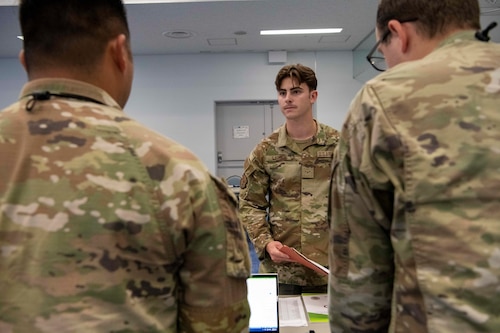 A military man speaks to two other military members.