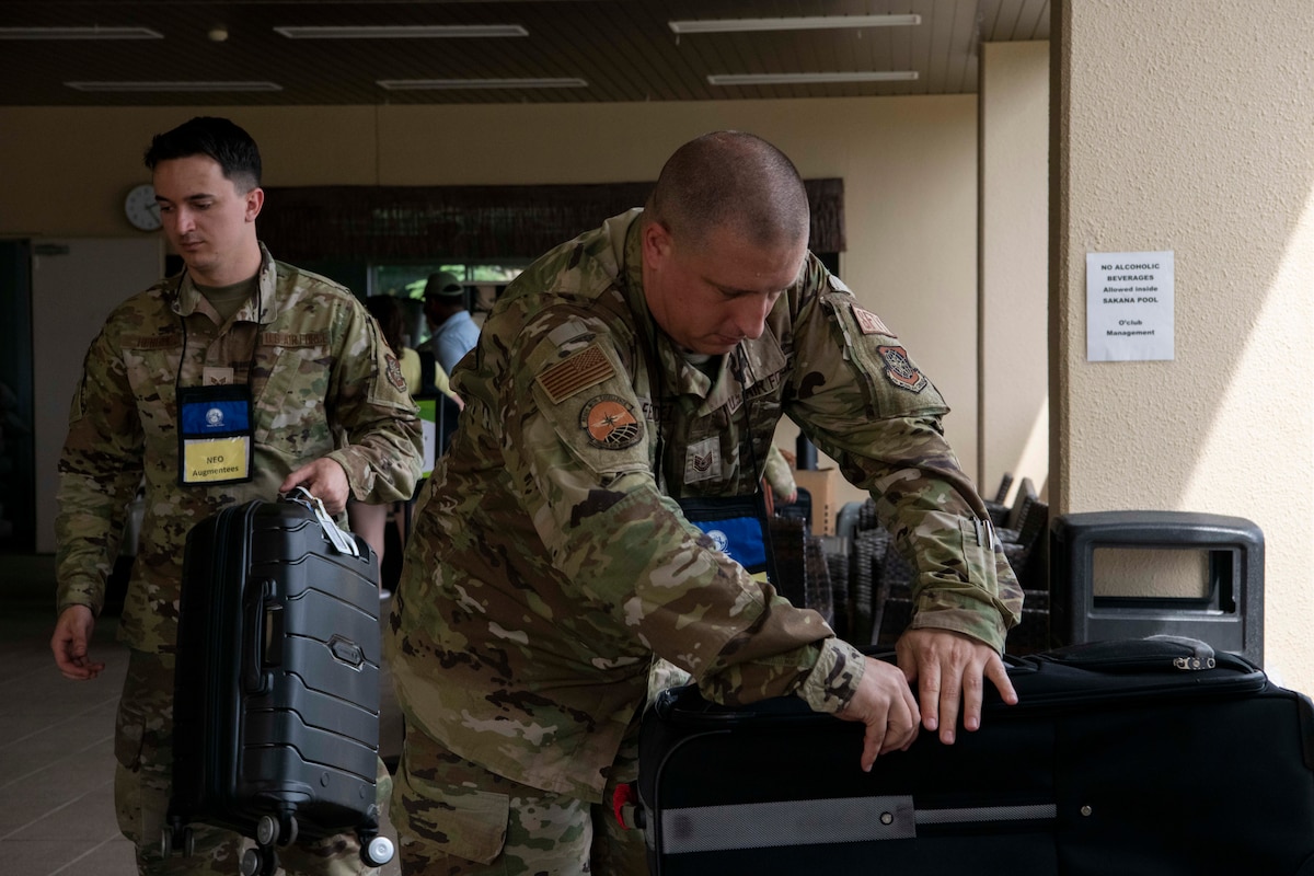 Military men look through luggage.