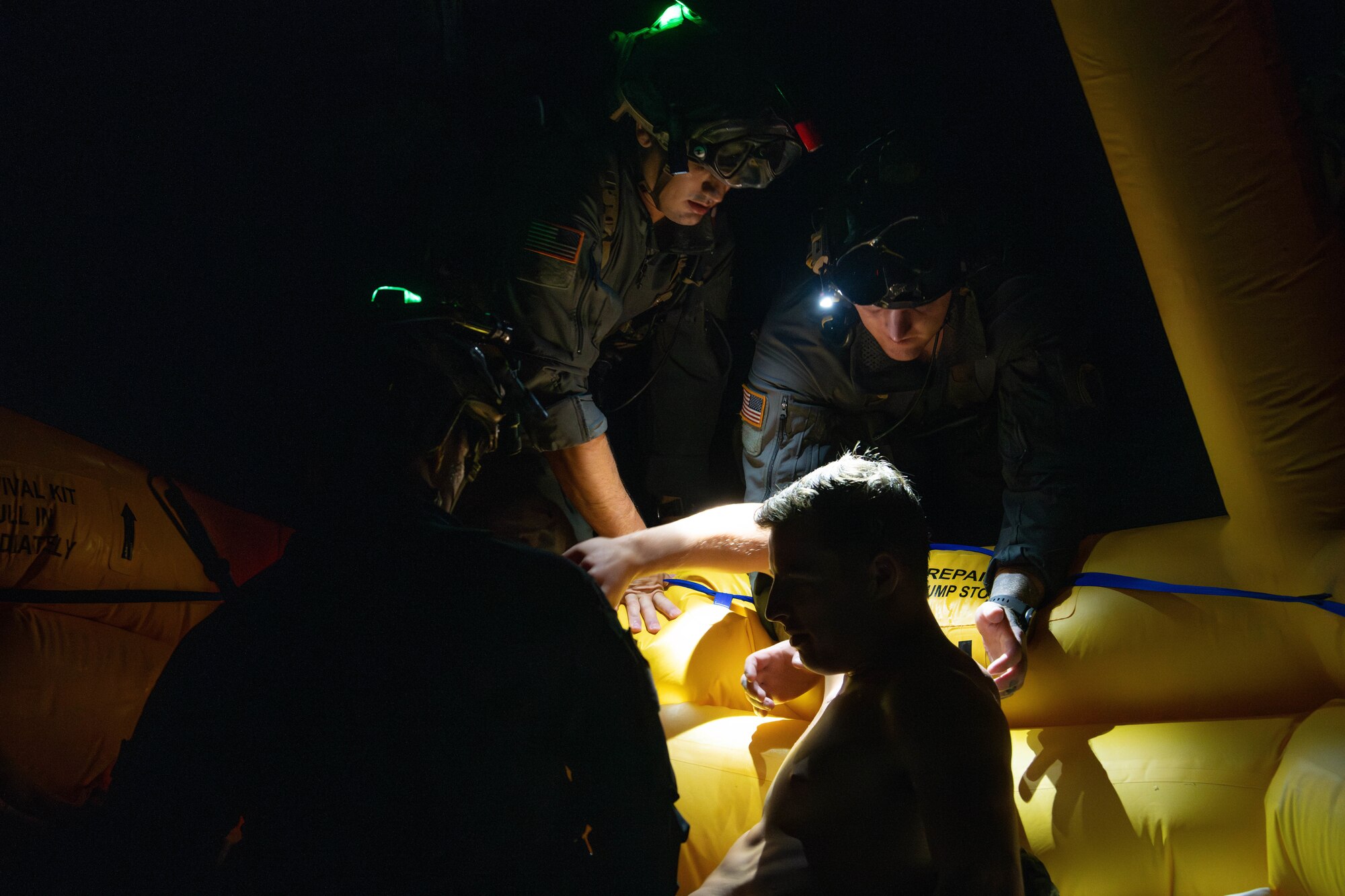pararescuemen  take injured airman from raft to boat