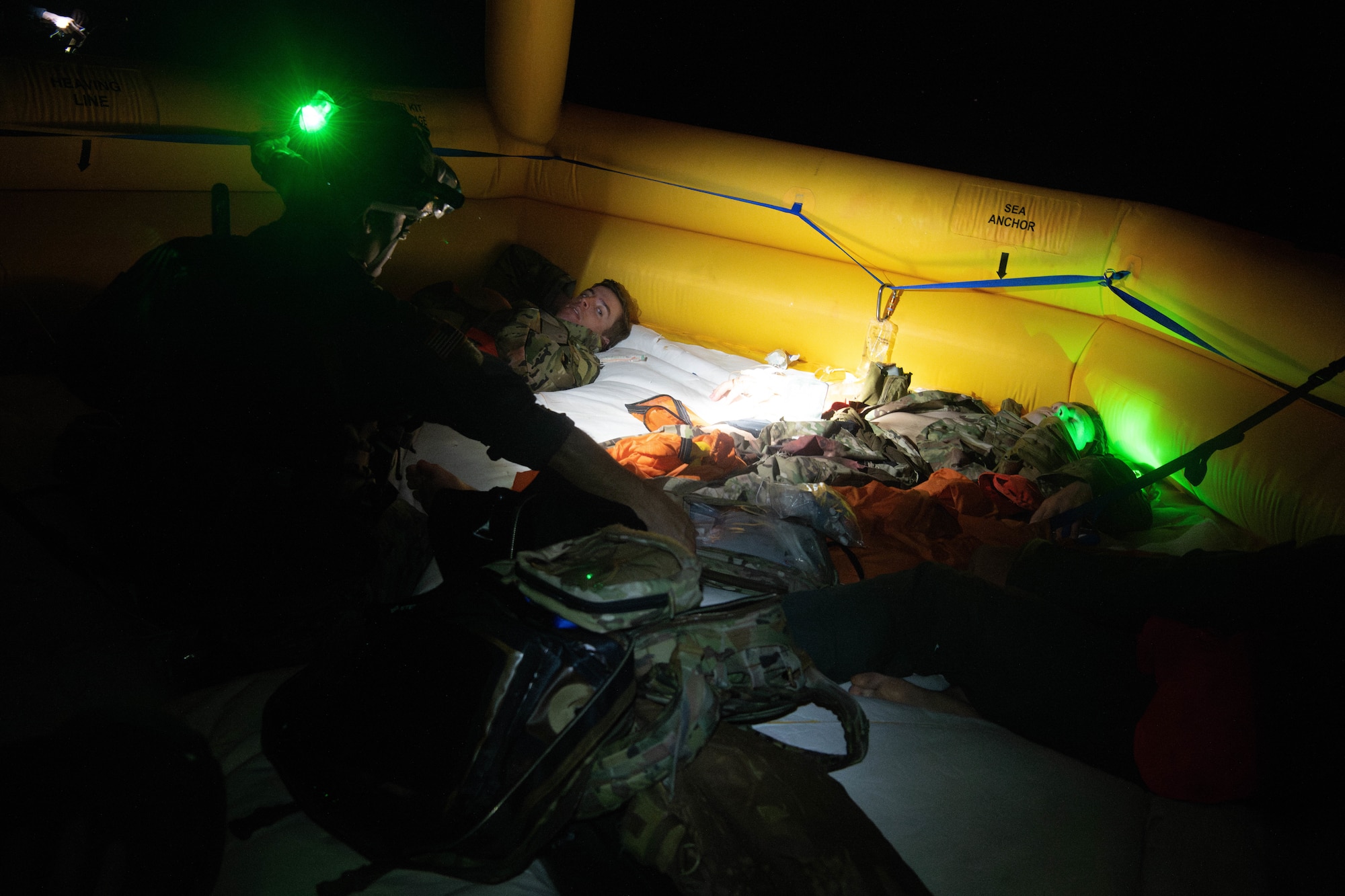 pararescuemen treats injured Airmen on raft
