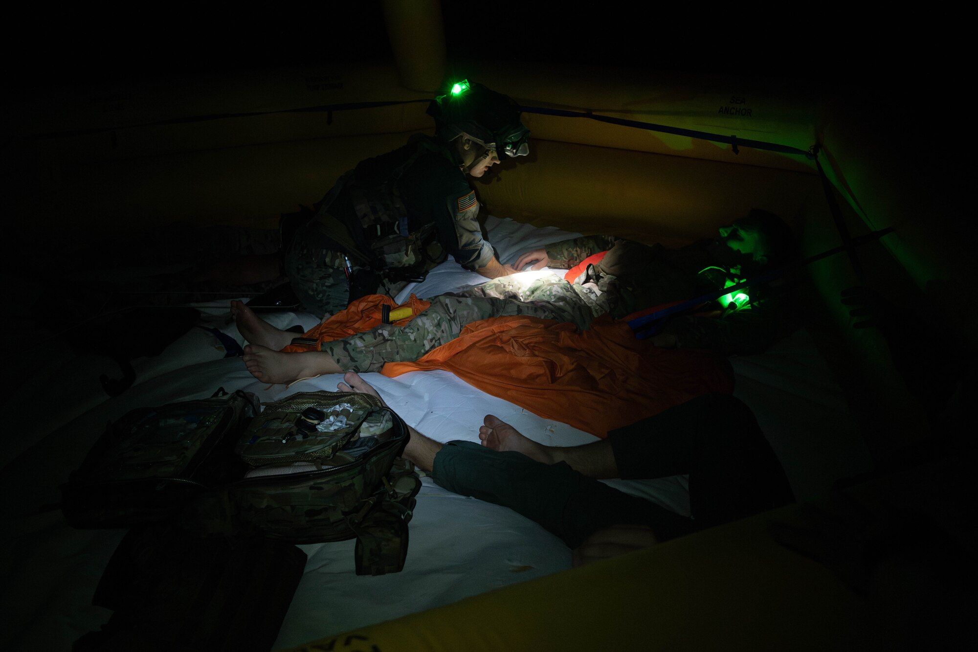 pararescuemen  treats airman in rescue raft