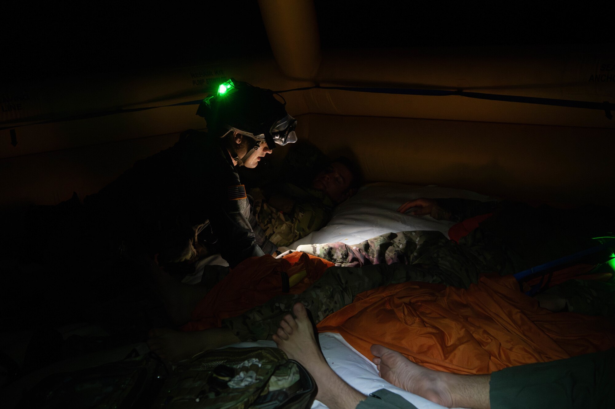 pararescuemen treats injured Airmen in rescue raft
