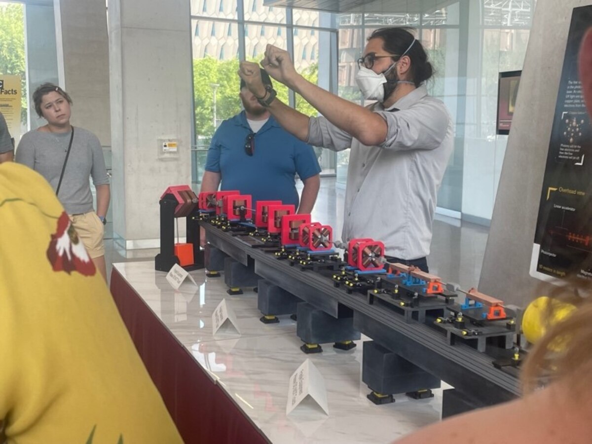 Dr. Samuel Teitelbaum, right, Arizona State University Assistant professor, demonstrates how light particles pass through a Compact X-Ray Free Electron Laser during a tour Aug. 10, 2023, part of the AFRL Junior Force Council Bluing Trip at Luke Air Force Base, Ariz. In addition to touring the base to get an understanding of missions and organizations that support the Air Force, JFC members toured ASU to deepen their understanding of support and collaboration between industry and the DOD. (U.S. Air Force photo / Kiara Palmer)