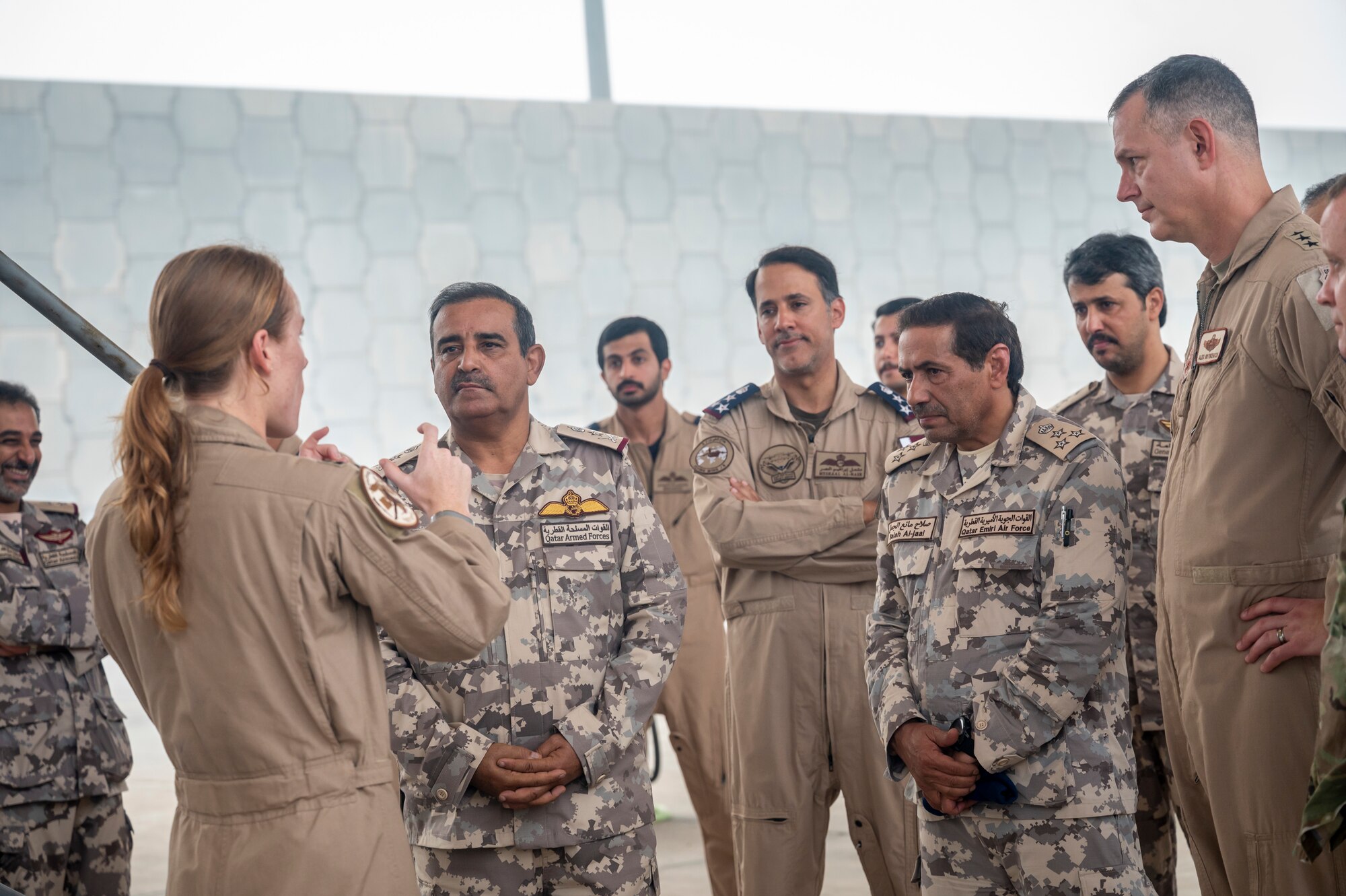 Group of military members talk to each other in front of an F-35