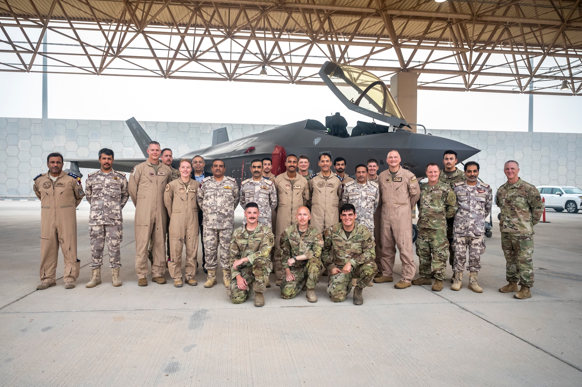 Group of military members pose in front of an F-35