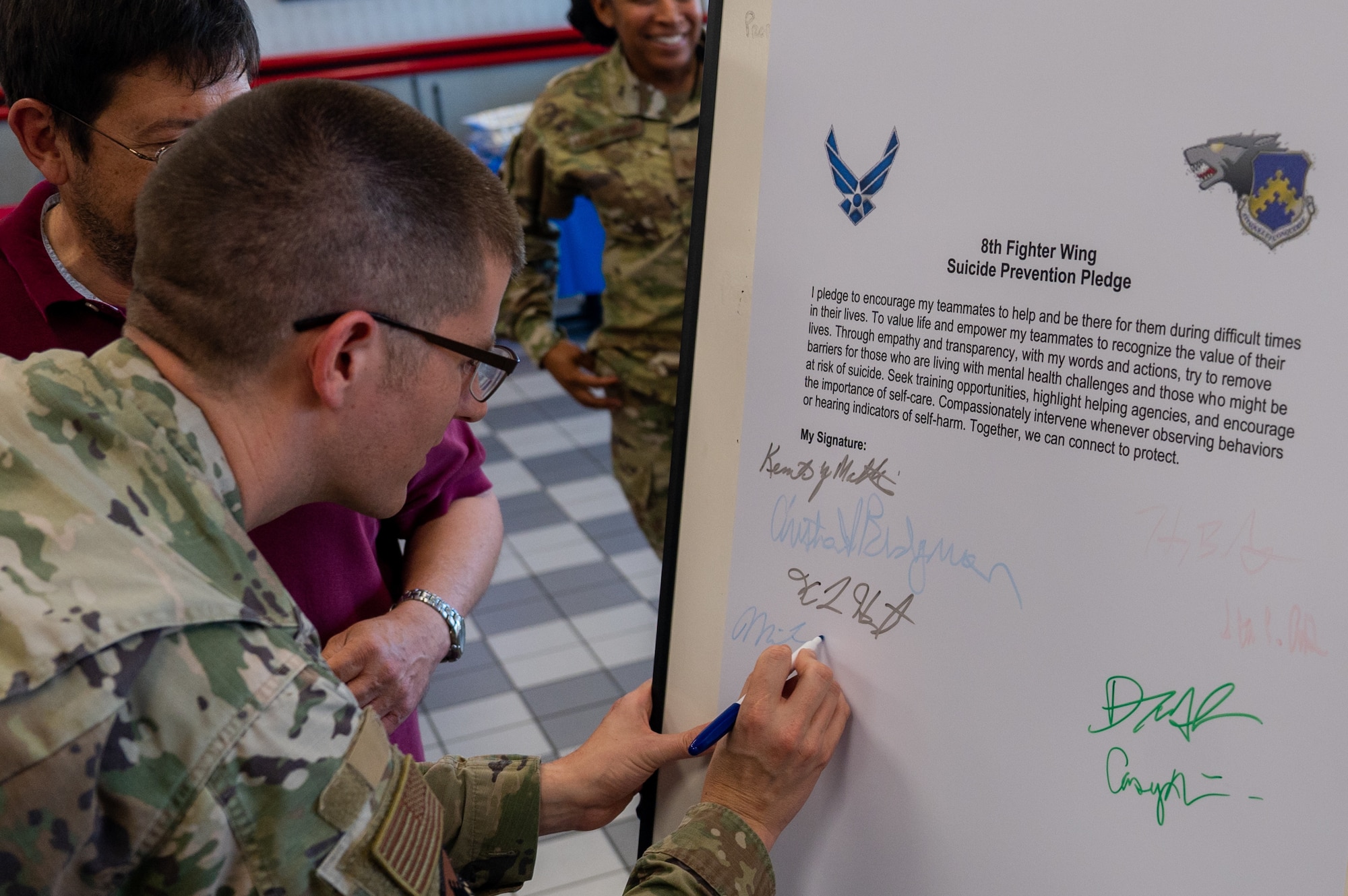 Lt. Col. Michael Carollo signs his name on the suicide prevention pledge board during the 2023 Suicide Prevention and Awareness Month opening event.