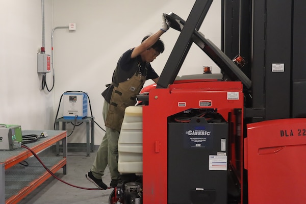 A man repairs a forklift.