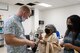 An ophthalmologist explains post surgical eye care to a patient and her family in the postoperative examine room.