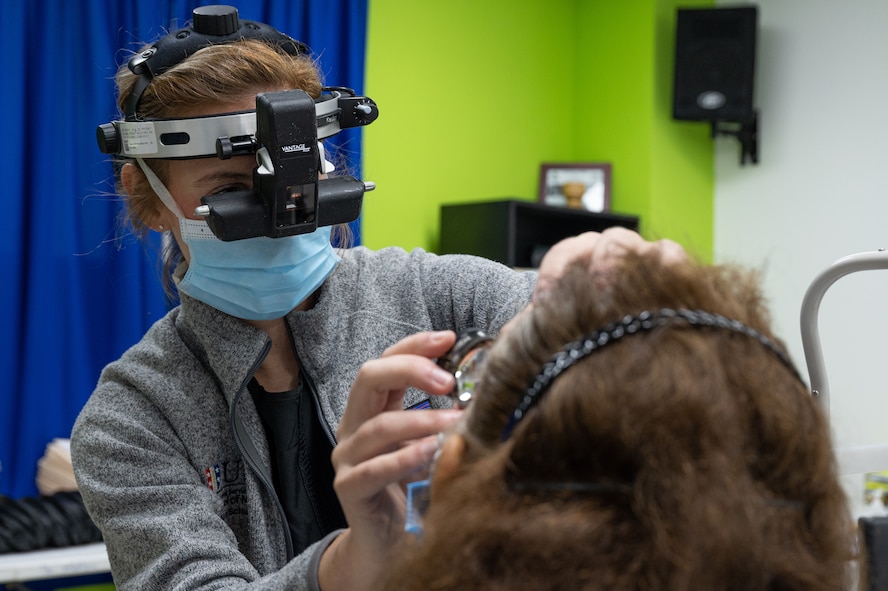 An ophthalmologist with the Panamax Alpha 2023 training mission examines a patient's eye during her three-day follow-up.