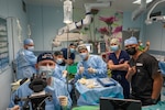 A group photo of ophthalmologists and medical technicians in one of three operating rooms where a manual small incision cataract surgery and pterygium excision are being performed.