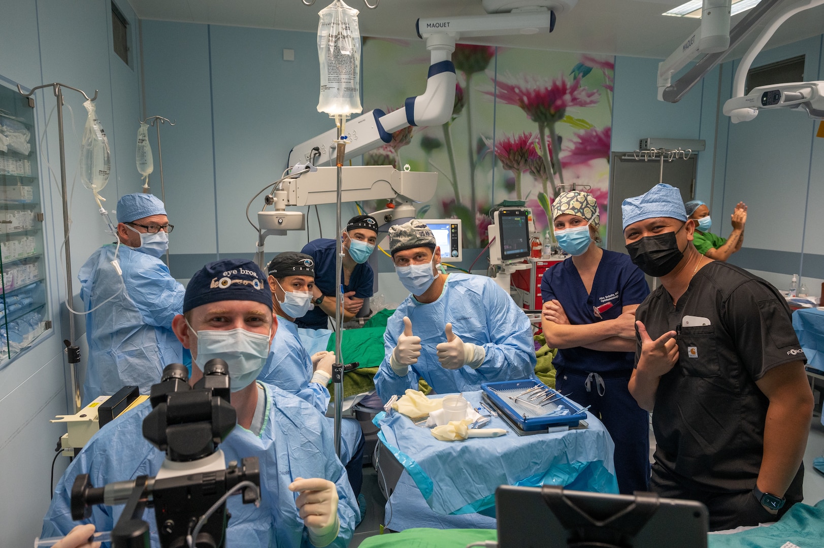 A group photo of ophthalmologists and medical technicians in one of three operating rooms where a manual small incision cataract surgery and pterygium excision are being performed.