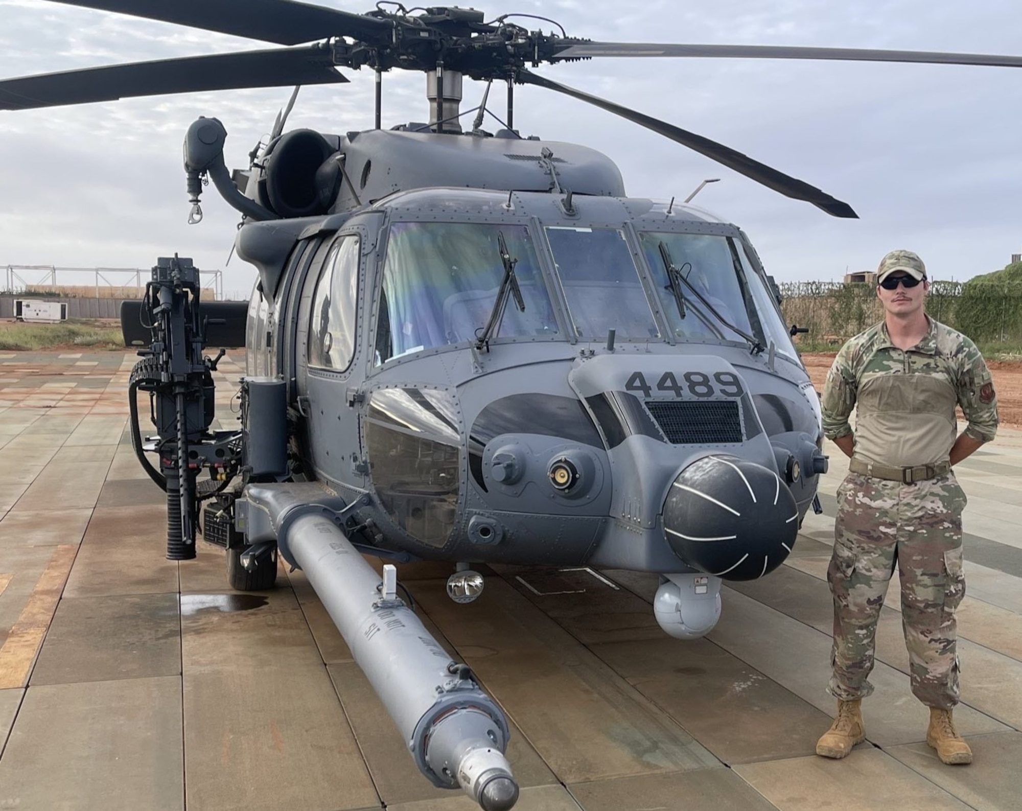 Photo of a man standing next to a helicopter