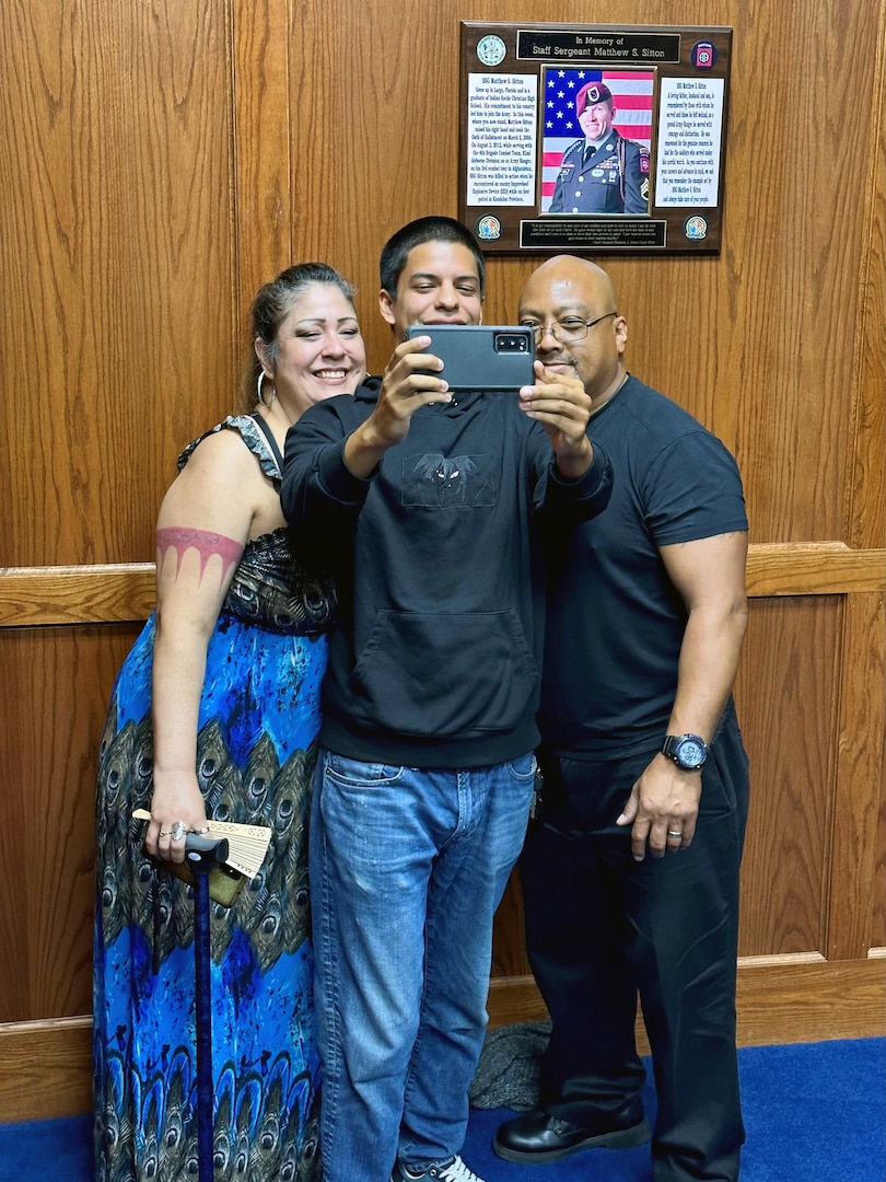 (Center) Christian Castro, Navy applicant, poses for a photo with his parents following his Oath of Enlistment at Tampa MEPS. USMEPCOM recently released policy allowing two guests per applicant about to ship to basic training, as well as National Guard and Reserve component applicants.