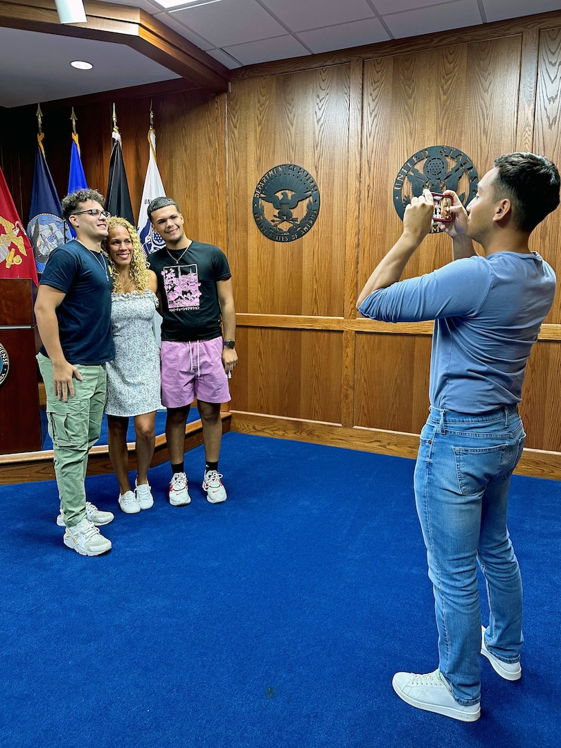 (L) Kevin Cruz, Navy applicant shipping from Tampa MEPS, poses for a photo with his mom and brother, following his Oath of Enlistment. USMEPCOM recently released policy allowing two guests per applicant about to ship to basic training, as well as National Guard and Reserve component applicants.