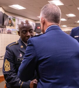 Maj. Gen. Rich Neely, the Adjutant General of Illinois and Commander of the Illinois National Guard, passes the noncommissioned officer sword to Command Sgt. Maj. Kehinde Salami, of Homewood, Illinois, during the change of responsibility ceremony Sept. 8 at the Illinois Military Academy, Camp Lincoln, Springfield, Illinois.