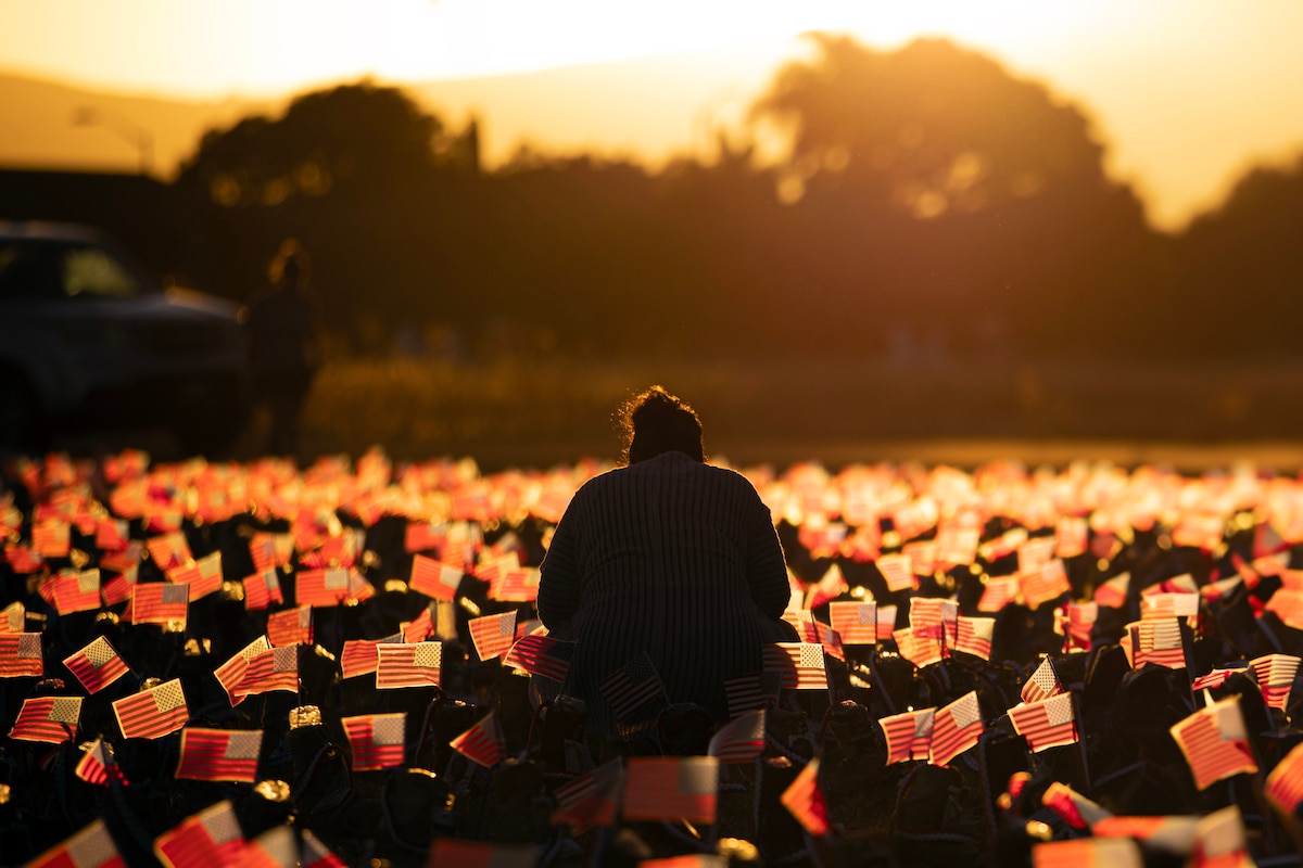 A visitor pays respects to fallen service members during the Boot Memorial Hero and Remembrance Run on Ford Island in Hawaii, Sept. 10, 2023. The event honored the more than 8,000 service members who have lost their lives in combat since Sept. 11, 2001.