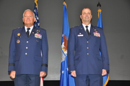 two men stand at attention during a ceremony