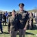 Male Soldier poses next to female Soldier outside at a graduation.