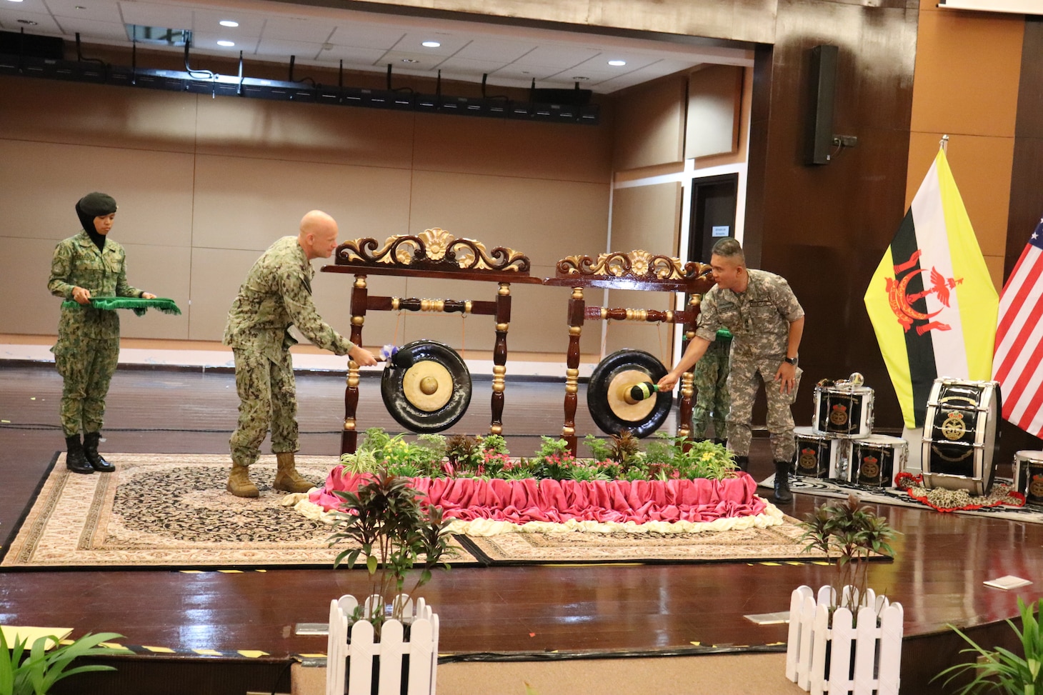 Capt. Matt Scarlett, deputy commodore of Commander Destroyer Squadron (DESRON) 7 rings the ceremonial gong with Royal Brunei Air Force Brig. Gen. Dato Seri Phlawan Alirupendi, joint force commander, during the opening ceremony of Cooperation Afloat Readiness and Training (CARAT) Brunei 2023 in Bandar Seri Begawan, Sept. 12.