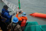 U.S. Coast Guard and U.S. Navy Supervisor of Salvage and Diving members test pollution containment and collection equipment near Seward, Alaska, Aug. 30, 2023.