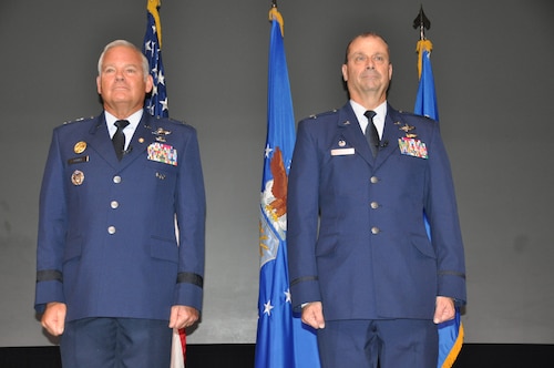 two men stand at attention during a ceremony