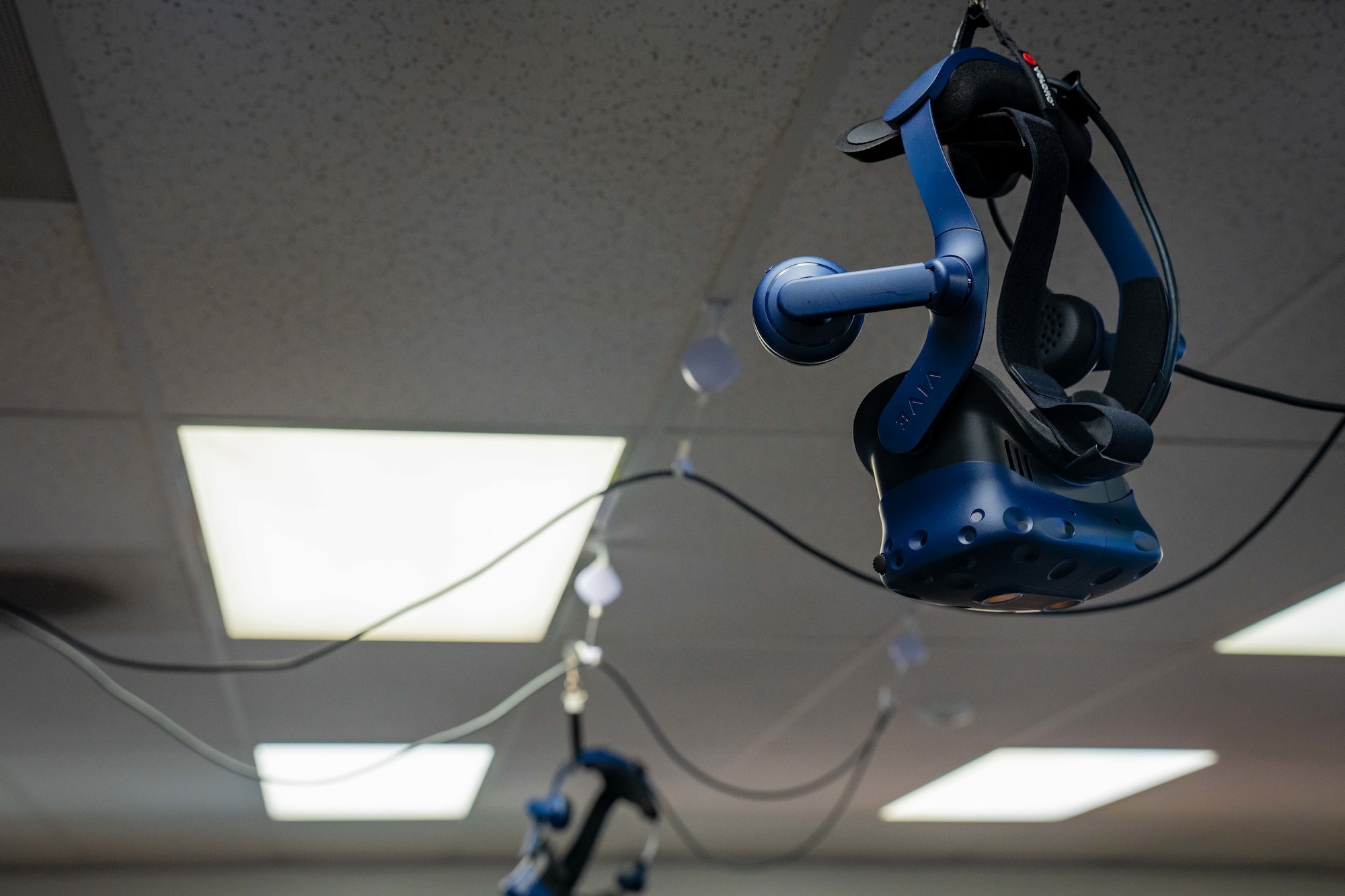A virtual reality headset hanging from the ceiling.